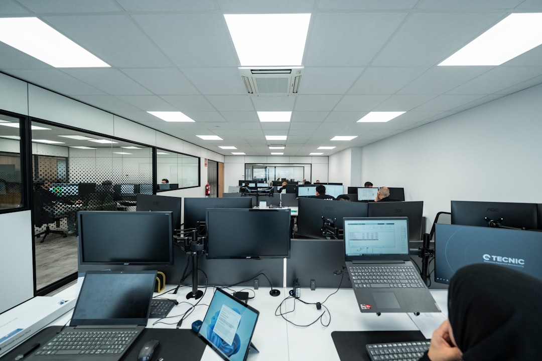 General view of a technical office with several employees working on computers in a modern and orderly environment.