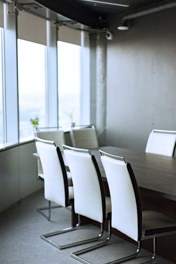 expertise-01 Spacious conference room with sleek furniture and large windows providing natural light.